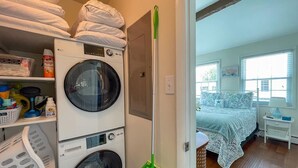 Un espace dédié à la lessive, avec des piles de serviettes, un lave-linge et un outil de nettoyage des sols.