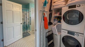 Une buanderie avec des piles de serviettes, un lave-linge et un sèche-linge.