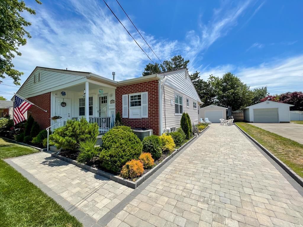 A two-story house with a front porch, a garage, and a well-maintained lawn.