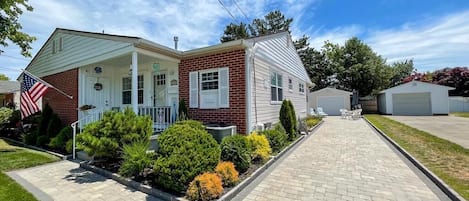 A two-story house with a front porch, a garage, and a well-maintained lawn.
