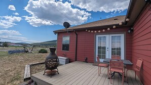 A red house with a deck, a grill, and a table with chairs. - Charming 2-bedroom B&B with WiFi, AC in gorgeous Williams (Williams)