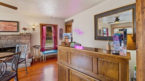 A reception area with a wooden counter, a mirror, a neon sign, and a fireplace. - Charming 2-bedroom B&B with WiFi, AC in gorgeous Williams (Williams)