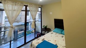 Una camera da letto con un letto, un tavolino e una finestra con tende.
