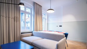 Une chambre moderne avec un canapé, une table et une vue sur l’extérieur grâce à de grandes fenêtres.