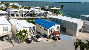 A coastal residential area with houses, a marina, and a clear view of the ocean. - Sailfish Haven #390 - Ocean Views, 35' seawall (Cudjoe Key)