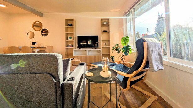 A modern living room with a sofa, a TV, and a bookshelf. - Bright 2BR, Cal King Bed, 15 Min walk to OSU (Corvallis)