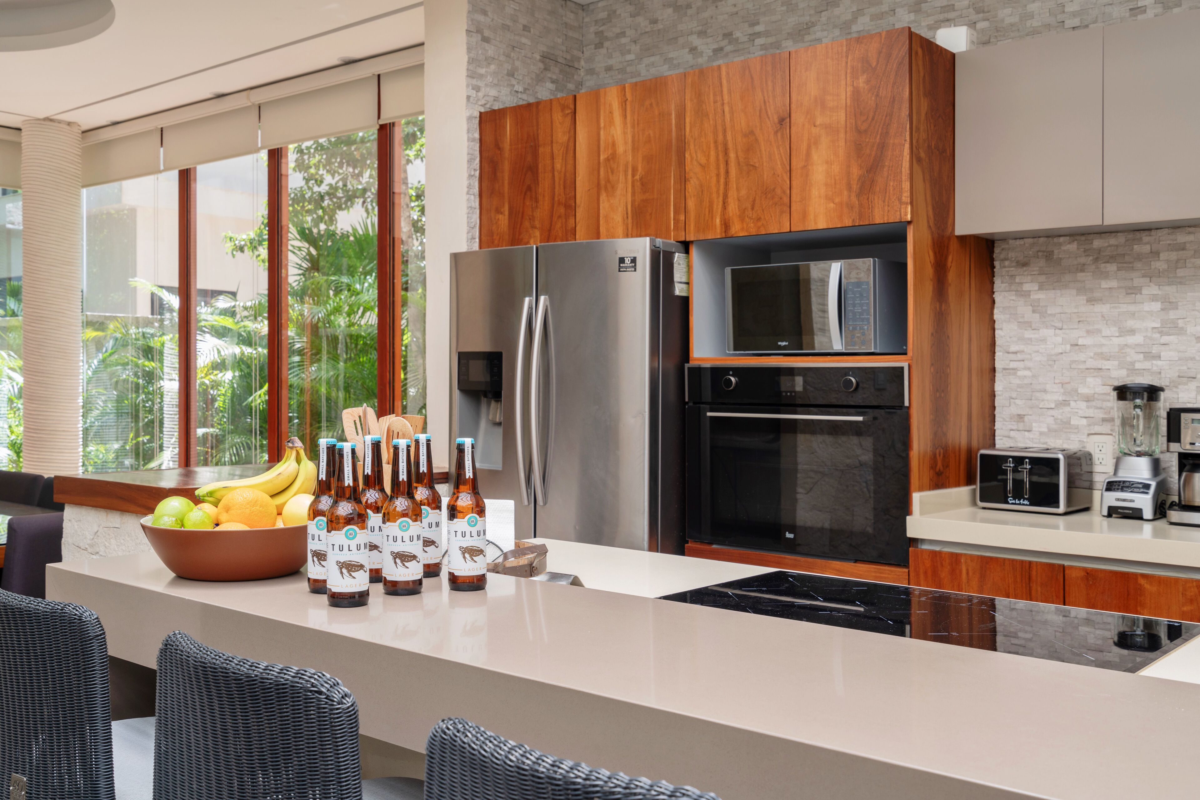 A modern kitchen with a large island, stainless steel appliances, and wooden cabinets.