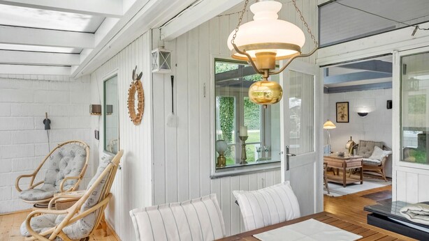 En matplats med ett träbord, flätade stolar och en hängande lampa.