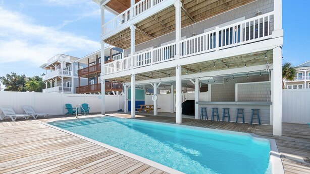 A multi-level house with a swimming pool, outdoor seating, and a covered patio area. - "Marina Jack" 5 Bedroom 5 Bath with a Pool! (Holden Beach)
