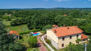 A two-story house with a red-tiled roof, surrounded by lush greenery and a swimming pool. - Villa Martina (Istria - Labin) (Šumber)