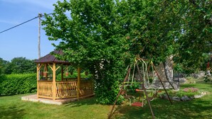 A gazebo with a tiled roof and a swing set in a lush garden. - Villa Martina (Istria - Labin) (Šumber)
