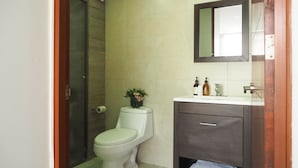 Een badkamer met een toilet, een wastafel en een spiegel.