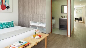 Een moderne hotelkamer met een bed, nachtkastje en uitzicht op de badkamer.