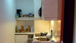 A compact kitchen with a refrigerator, sink, and a small countertop.