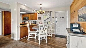 A kitchen with wooden cabinets, a microwave, and a chandelier. - Sleeps 6 Mountain Views Shared Resort Amenities (Gatlinburg)