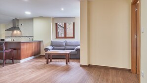 Una cocina moderna con una isla integrada, un sofá gris y una mesa de centro de madera.