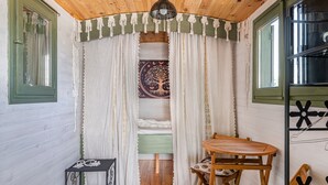 A cozy room with a bed, a small table, a chair, and a window with curtains. - Spacious, Bright and Welcoming Gîte with Mountain View, Private Terrace and Air Conditioning (Beaujeu)