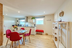 Eine kleine Küche mit Essbereich, Holzboden und einer roten Bank.