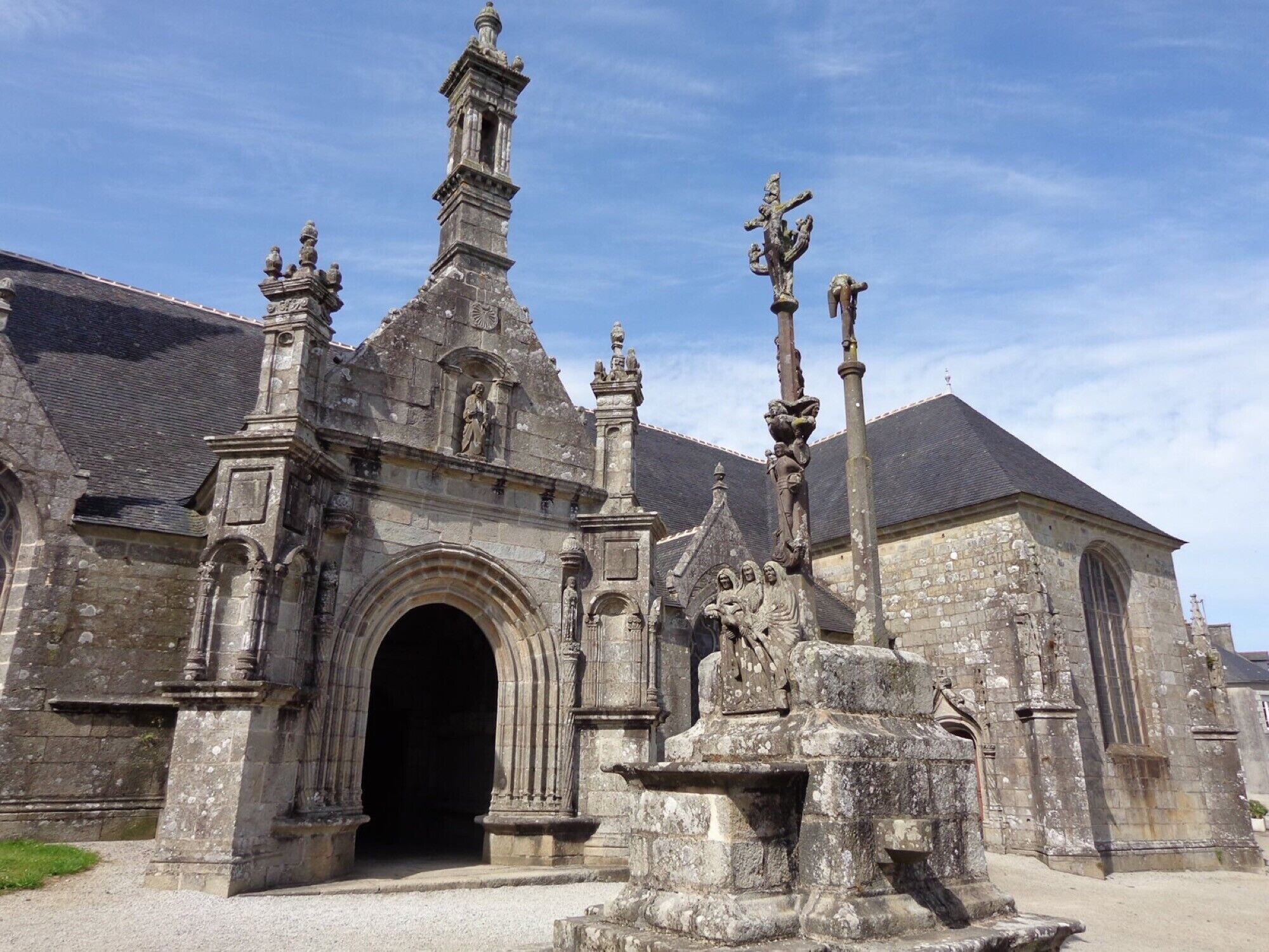 Eine historische Kirche mit markantem Eingang, einem Glockenturm und Statuen.