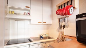 Una cocina con armarios blancos, lavavajillas, estufa y microondas.