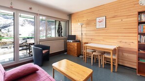 Una habitación moderna con una pared de madera, un escritorio, una silla, un sofá y una estantería.