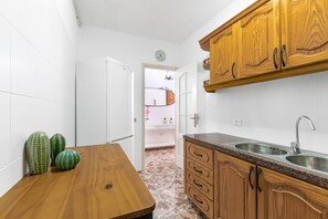 A kitchen with wooden cabinets, a granite countertop, and a sink.