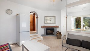 A modern kitchen with a white refrigerator, a dining table, and a sofa. - Country House 'Carrion' with Sea View, Wi-Fi and Air Conditioning (Periana)