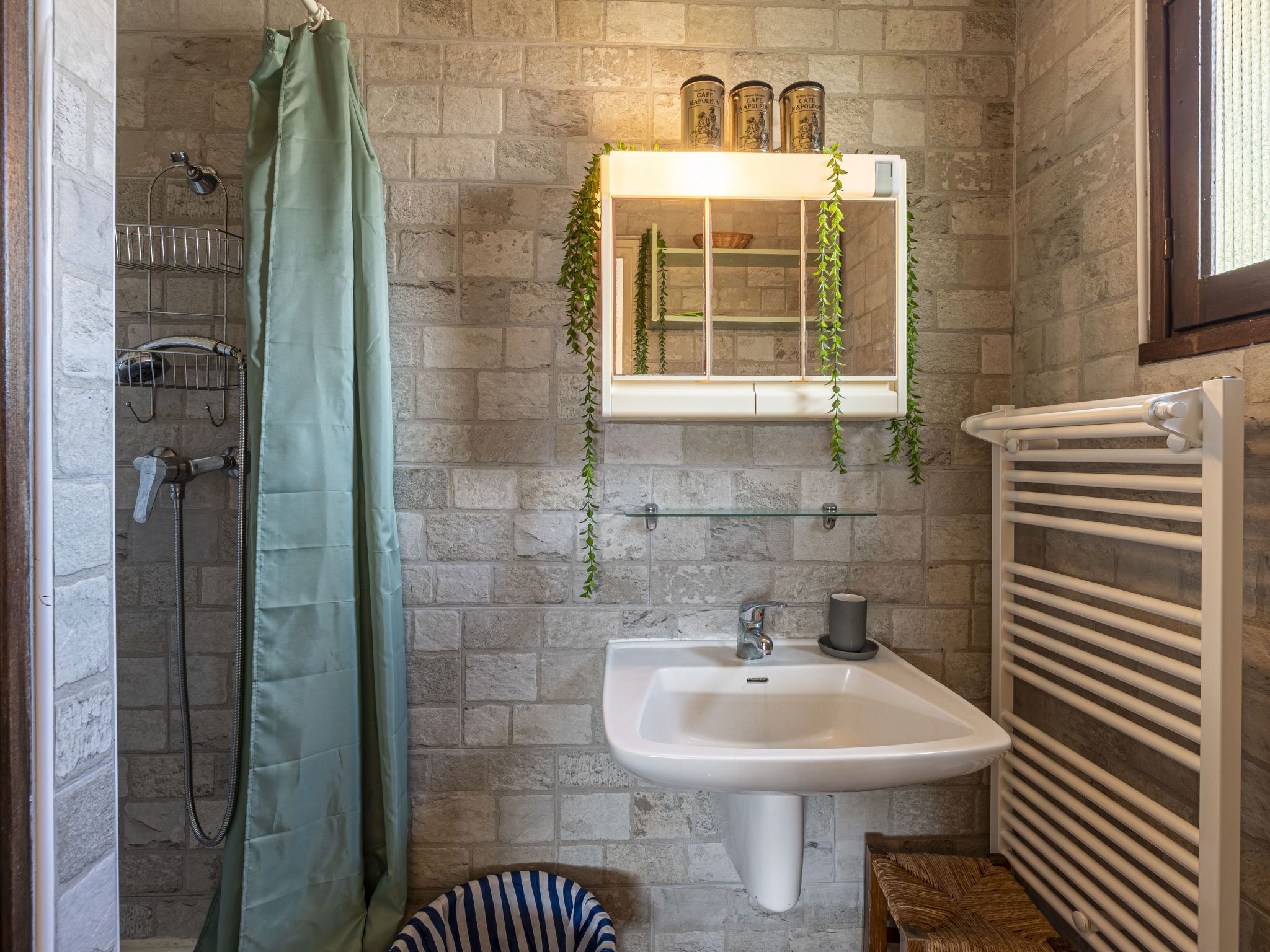 Un baño con ducha, lavabo y toallero.