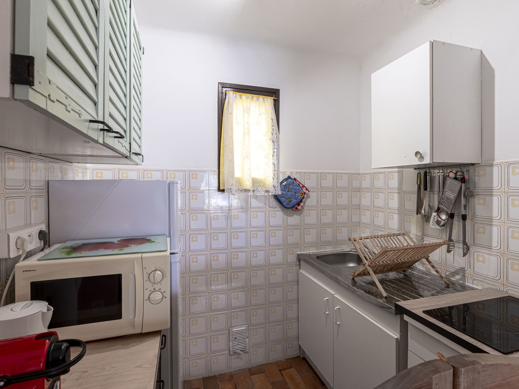 A compact kitchen with a microwave, a sink, and a stove.