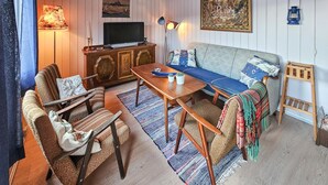Un salon confortable avec un canapé, une table basse en bois, un téléviseur et une lampe.