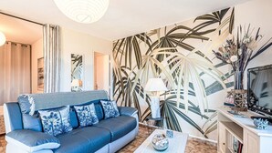 Un salon moderne avec un canapé, une table basse et un téléviseur.