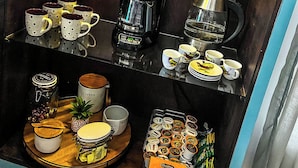 Ein Kaffee-Bereich mit einer Kaffeemaschine, Tassen und verschiedenen Kaffeekapseln.