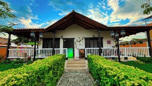 Ein traditionelles Haus mit einem Ziegeldach, einer weißen Veranda mit Geländer und einer grünen Tür.