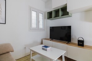 Relax in this stylish living space with a flat-screen TV, comfortable sofa, and ample shelving for your belongings.
