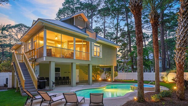 A two-story house with a covered patio and a swimming pool.