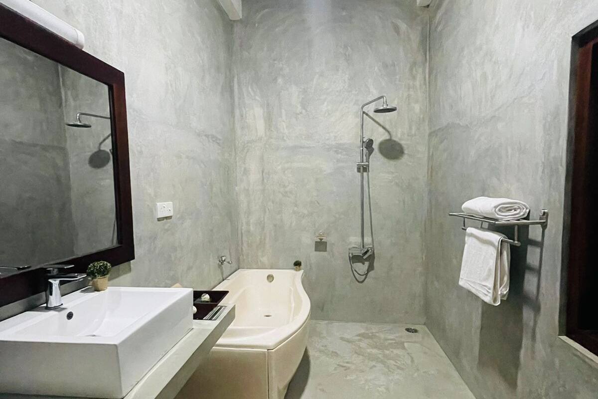 Een moderne badkamer met een groot bad, een wastafel en een douche.