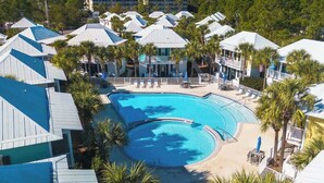 A resort with a large central pool, multiple buildings with white roofs, and palm trees. - Coast & Key Cottage by Stay on 30a (Seagrove Beach)