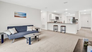 Een moderne woonkamer met een bank, salontafel en een schilderij aan de muur.