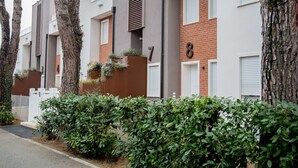 A row of modern apartment buildings with a mix of brick and concrete facades, white shutters, and a number '8' sign.