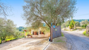 A rustic building with a gravel driveway, a small porch, and a stone wall. - CAN GARDO - Villa with private pool and Free Wifi (Pollença)