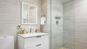 A modern bathroom with a white vanity, a glass shower enclosure, and a marble backsplash. - Luxury King Retreat Room (Providenciales)