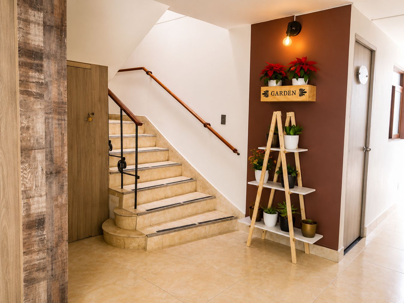 Eine Treppe mit einem Holzgeländer und beigen Stufen, die zu einer Zwischenebene mit einer Wandleuchte und einem Regal mit Blumentöpfen führt.