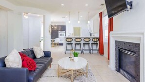 A modern living room with a sofa, a round coffee table, and a fireplace. - Stylish Indio Sanctuary with Heated Pool (Indio)