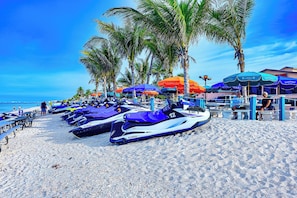 A beach with jet skis lined up, palm trees, and beach umbrellas. - Charming 2 bedroom cottage in the heart of wonderful Bonita Springs Florida (Bonita Springs)