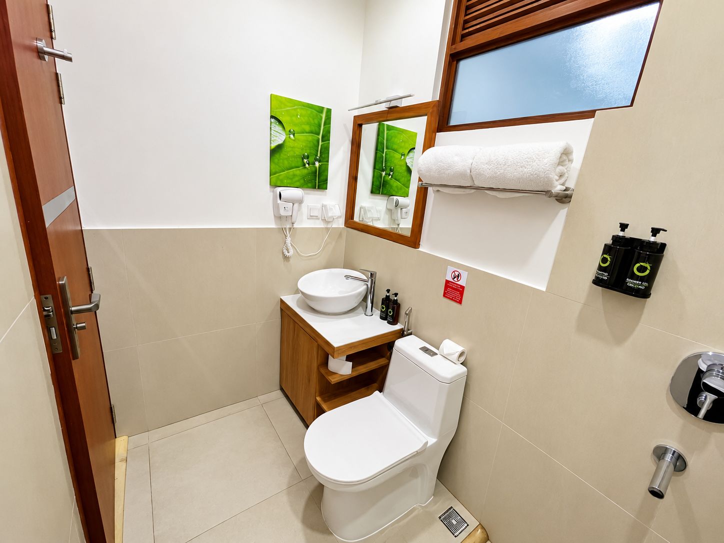 Une petite salle de bain comprenant des toilettes, un lavabo et un porte-serviettes.