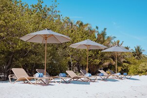 Playa privada, arena blanca, sillas reclinables de playa, sombrillas