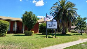 Een motel, Junction Motel genaamd, met een bord waarop zwembad en WiFi staan.