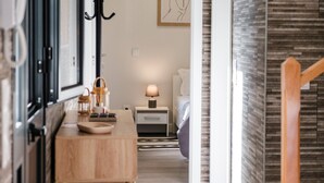 A modern hotel room with a wooden desk, a bedside table with a lamp, a bed, and a view of the outside. - GuestReady - Tranquil Hideaway near Funchal (Funchal)