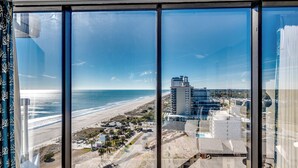 A large window with a view of a beach and buildings. - Sweeping Ocean View from Each Bdr and Living Room, Safe and Quiet Neighborhood  (Myrtle Beach)