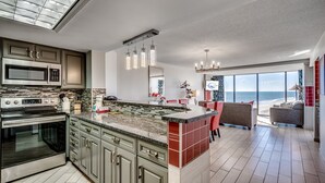 A modern kitchen with a large island, stainless steel appliances, and a view of the ocean. - Sweeping Ocean View from Each Bdr and Living Room, Safe and Quiet Neighborhood  (Myrtle Beach)